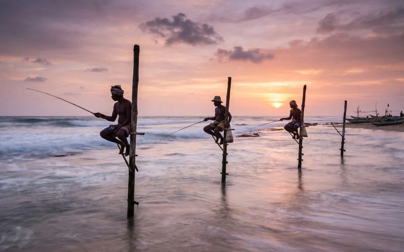 Long exposure photo of a traditional stilt fisherman balanced above the sea at Koggala