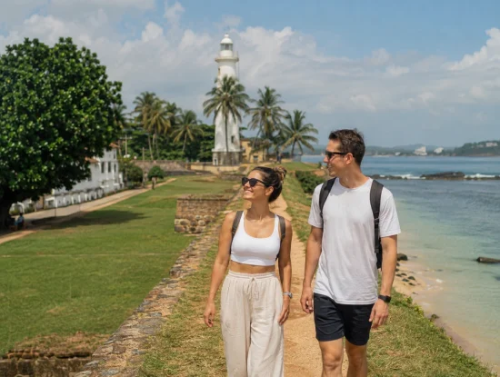 Couple walking along the Galle Fort ramparts near the lighthouse